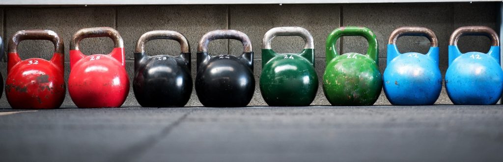 A row of colorful kettlebells representing strength training